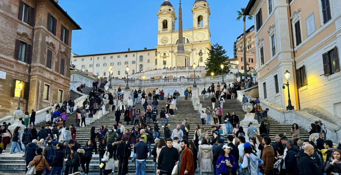 Turistas disfrutando de la Escalinata Española en Roma al atardecer.