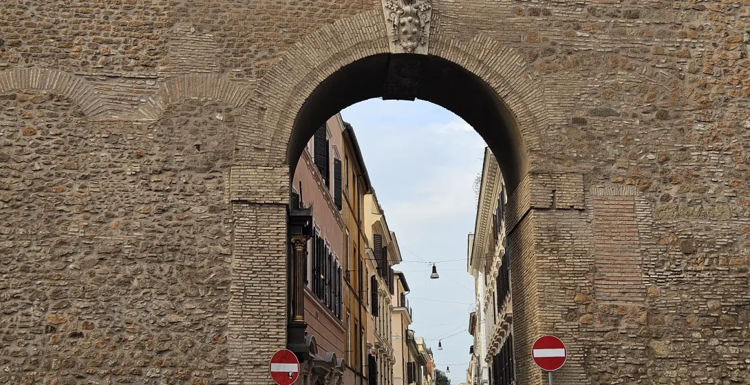 Antiguo arco romano en Roma, ofreciendo una vista de una encantadora calle.