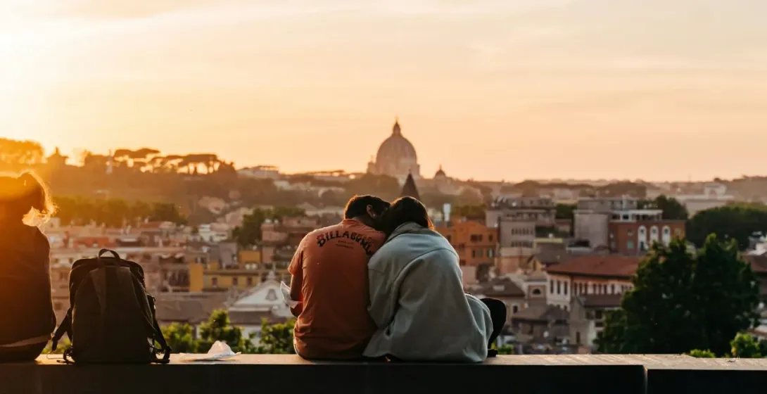 Parejas disfrutando de la puesta de sol sobre Roma con la Basílica de San Pedro al fondo.