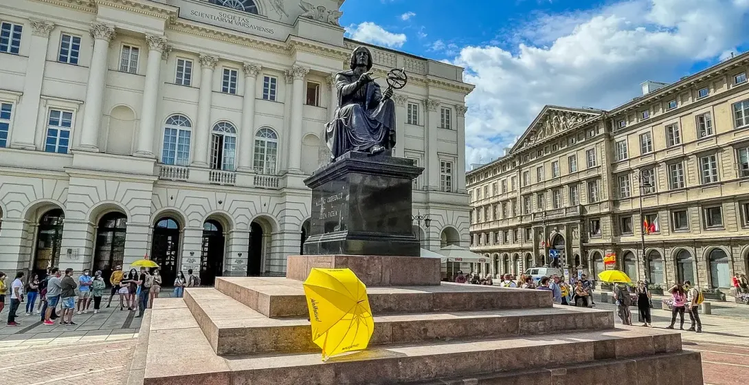 Turistas explorando el Monumento a Copérnico en el casco antiguo de Varsovia.