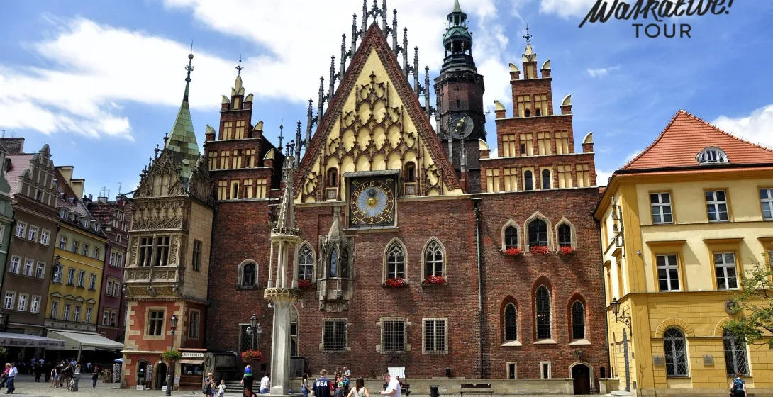 Tourists enjoying a free Walkative! tour in Wrocław's Old Town Square, admiring the stunning Old Town Hall.