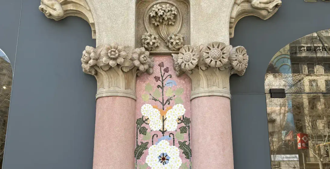Floral mosaic and carved stone columns at Casa Lleó Morera's facade on Passeig de Gràcia, Barcelona.