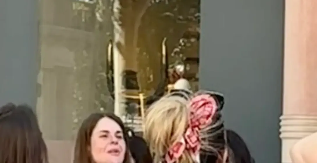 Personas en una calle de Barcelona, frente a la fachada de una tienda Loewe con detalles arquitectónicos ornamentados, bal...