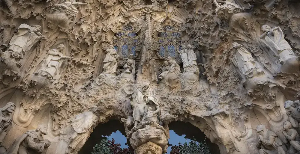 Highly detailed stone facade of Sagrada Familia's Nativity Facade, featuring numerous religious sculptures, intricate carv...
