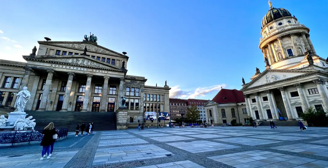 Vista de Gendarmenmarkt en Berlín con el Konzerthaus (izquierda) y el Deutscher Dom (derecha) bajo un cielo azul claro.