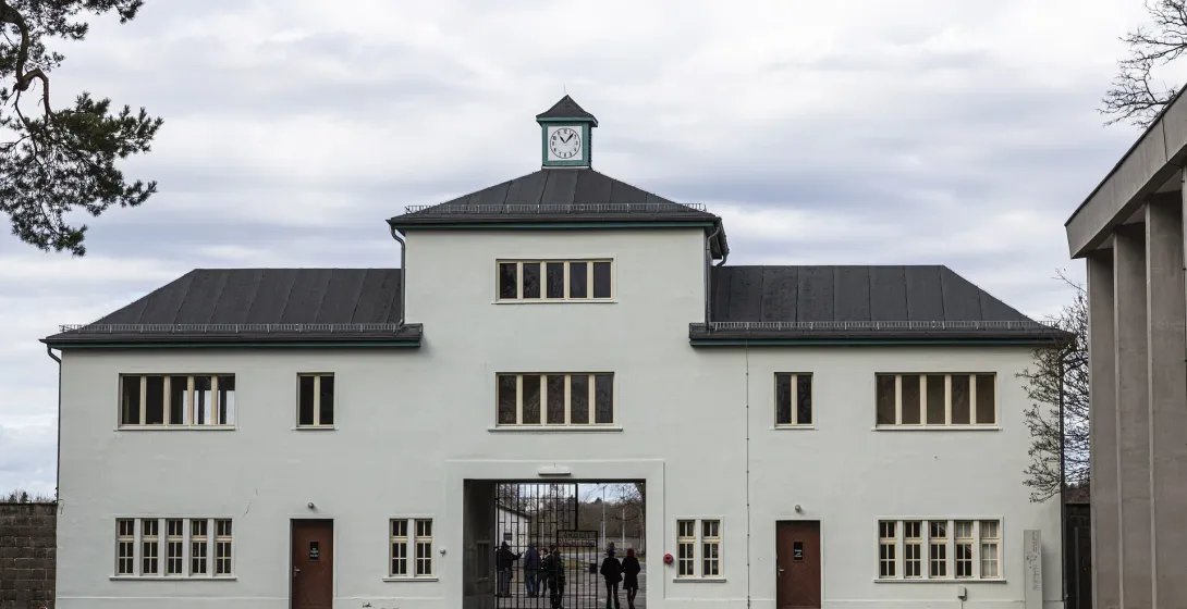 Brama wejściowa do miejsca historycznego, z turystami przechodzącymi przez nią.