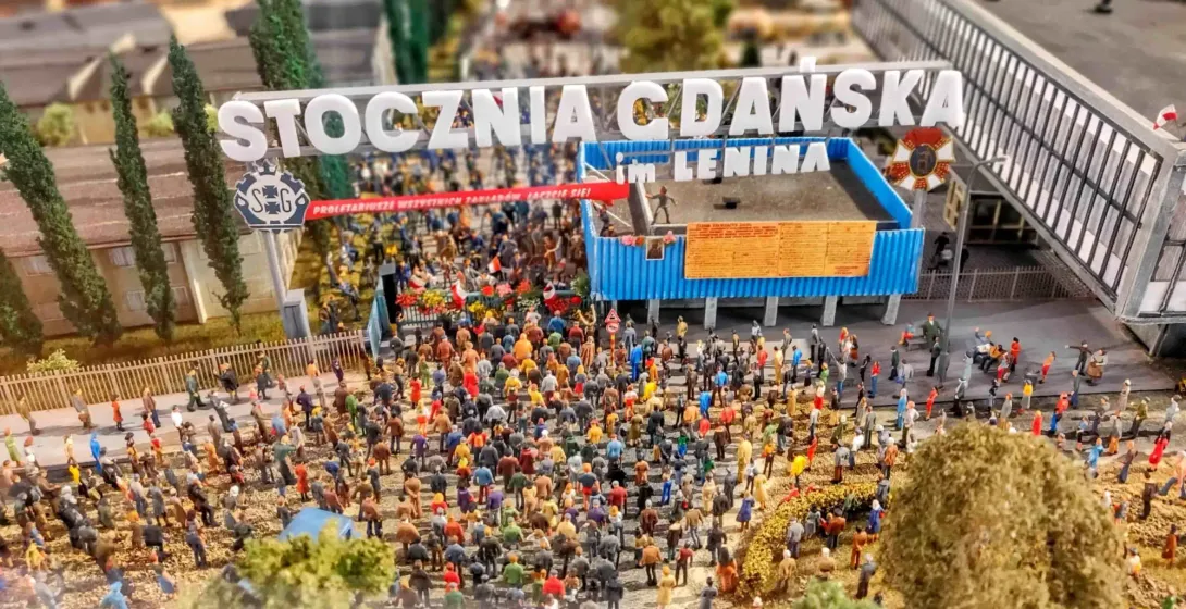 Miniaturowy model Stoczni Gdańskiej z tłumem ludzi pod napisem "STOCZNIA GDAŃSKA im. LENINA".
