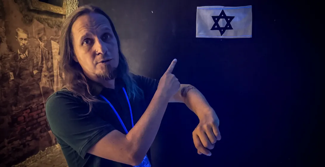 Tour guide pointing to a Jewish arm band with a Star of David at Schindler's Factory Museum in Krakow.