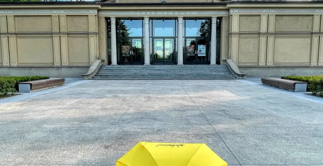 A yellow Walkative umbrella on the plaza in front of the Teatr Ludowy (People's Theatre) in Krakow's Nowa Huta district.