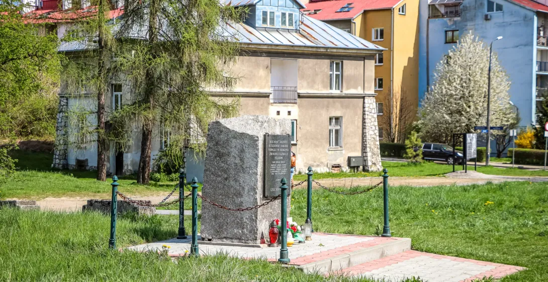 Ein Gedenkstein auf einer Wiese vor dem historischen Grauen Haus auf dem Gelände des ehemaligen KZ Plaszow in Krakau.