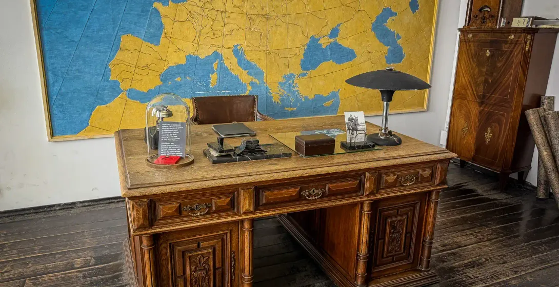 A meticulously recreated office space with a large wooden desk and a vintage map of Europe on the wall, evoking the atmosp...