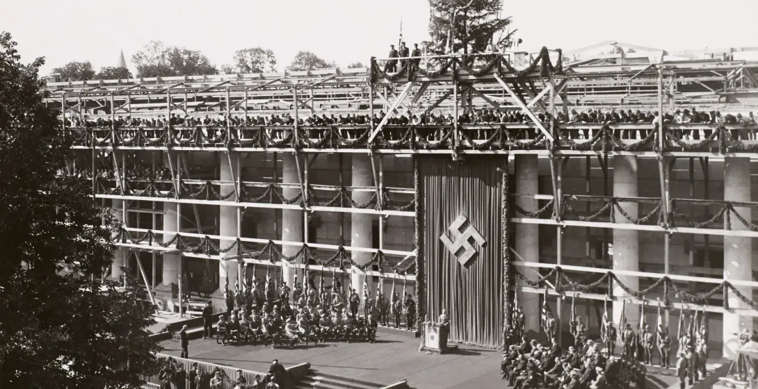Historical photo of the Haus der Kunst topping-out ceremony in Munich, featuring scaffolding and Nazi banners.