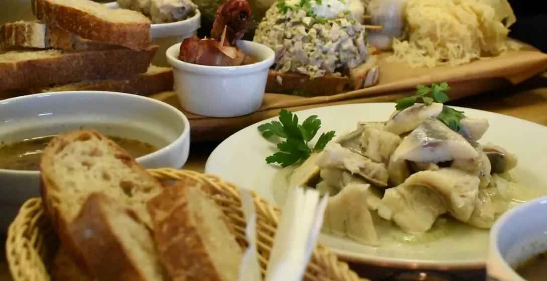 Traditional Polish food including herring, bread, and soup on a table in Krakow.