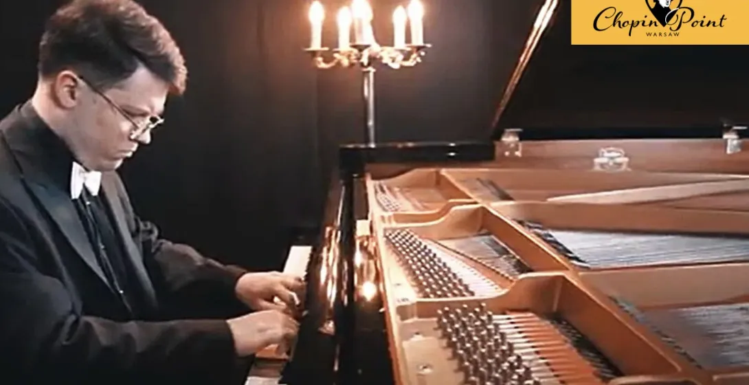 Woman in a green dress sitting at a grand piano in an empty concert hall.