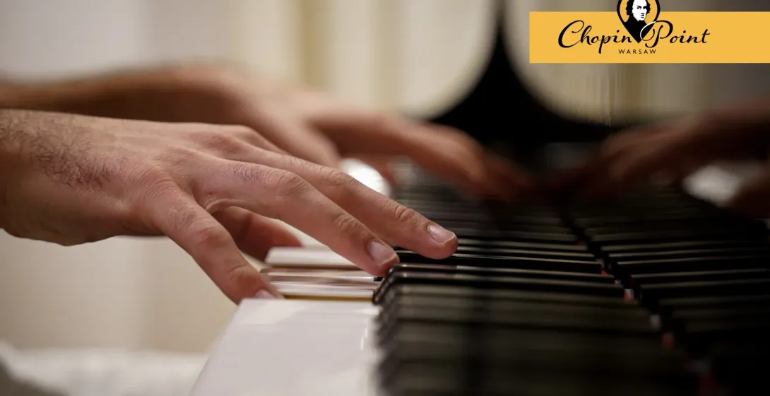 Close-up of a person's hands playing black and white piano keys during a performance.