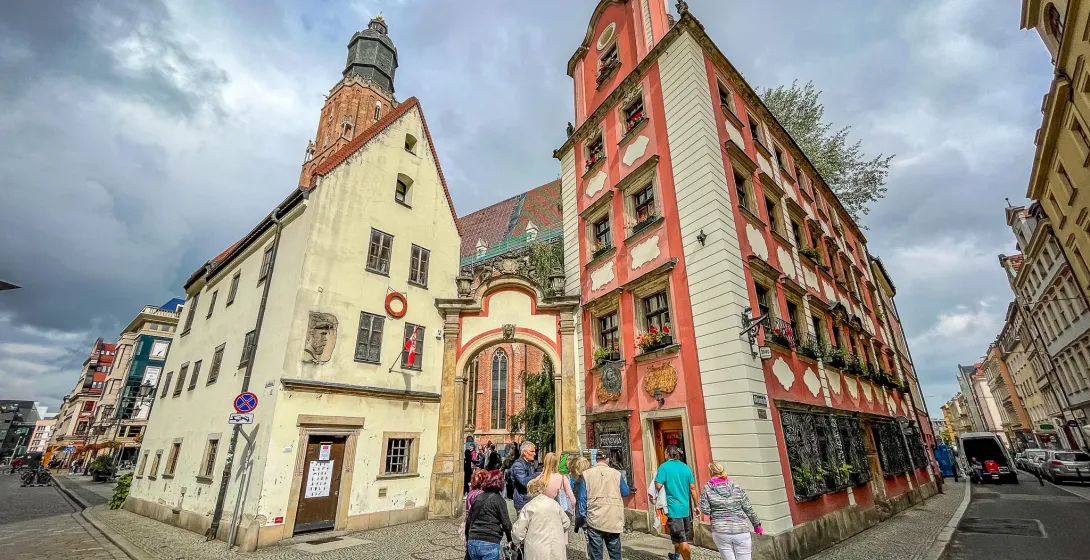 Eine Reisegruppe erkundet die historischen Straßen von Wrocław, Polen, und passiert wunderschöne Gebäude.