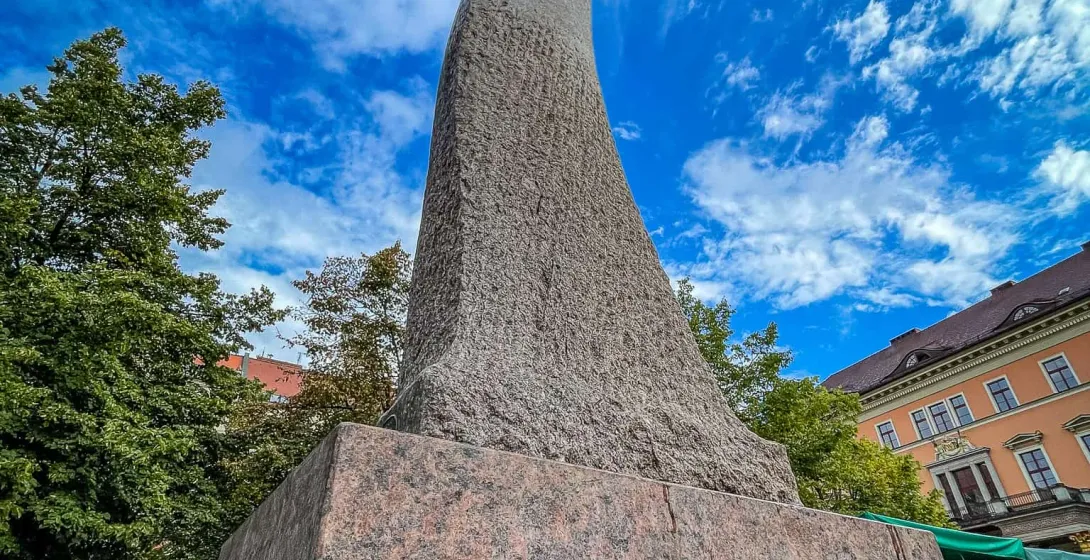 Tall abstract stone monument in Wrocław, Poland, against a blue sky.