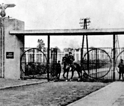 Puerta histórica con una figura a caballo.