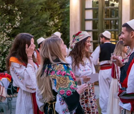 Turyści cieszą się albanańskim pokazem nocnym, wchodząc w interakcję z wykonawcami w tradycyjnych strojach.