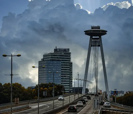 Dramatische Aussicht auf die UFO-Brücke und den Aussichtsturm von Bratislava unter einem stürmischen Himmel.