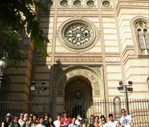 Grupa turystów pozuje przed wspaniałą synagogą na ulicy Dohány w Budapeszcie.