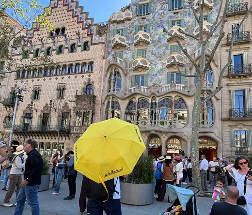 Turyści zwiedzają pełną życia mozaikową architekturę Parku Güell w Barcelonie.