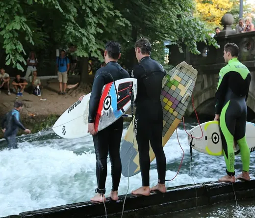 Surfers prepare to ride the Eisbach wave in Munich's Englischer Garten.