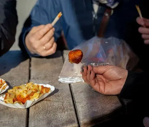Turyści jedzą Currywurst w Berlinie.