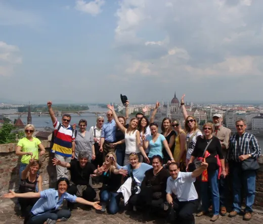Feliz grupo de turistas en Budapest, Hungría, con el edificio del Parlamento al fondo.