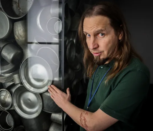 Reisegruppe hört einem Reiseleiter in einer Museumsausstellung zu.