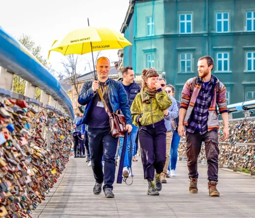 Eine Walkative-Reisegruppe erkundet Krakau, Polen, und geht über eine Brücke, die mit Liebesschlössern bedeckt ist.