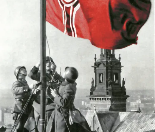 Soldaten hissen eine Flagge auf einem Dach in Krakau.