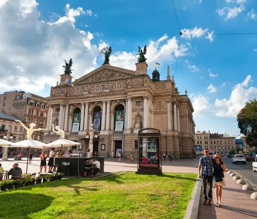 Turistas disfrutando de la soleada plaza frente al magnífico Teatro de la Ópera de Lviv en Ucrania.
