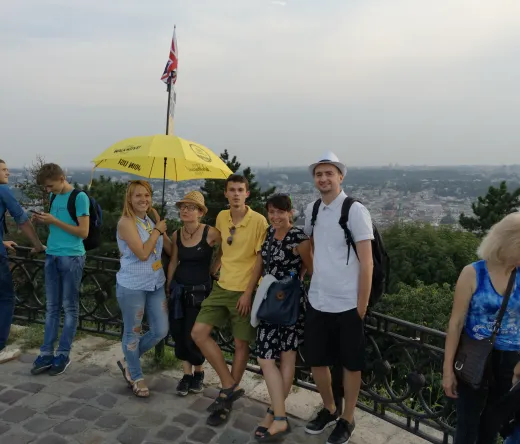 Un grupo de turistas en una visita guiada a pie en Lviv, Ucrania, disfrutando de una vista panorámica de la ciudad.
