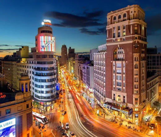 Night view of Madrid's Gran Vía, showcasing its vibrant architecture and bustling street life.