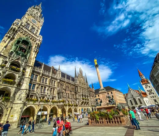 Tourists exploring Marienplatz in Munich, Germany, with the iconic New Town Hall in the background.
