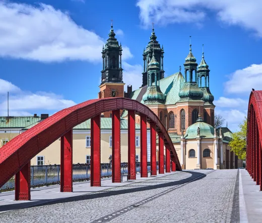 Red bridge in Poznan, Poland, with the Poznan Cathedral in the background.