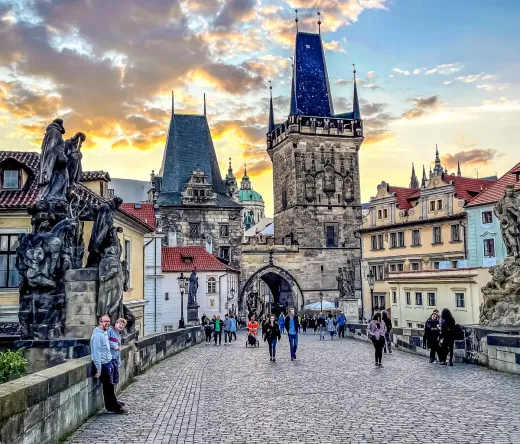 Touristen genießen einen Spaziergang über die Prager Karlsbrücke bei Sonnenuntergang.