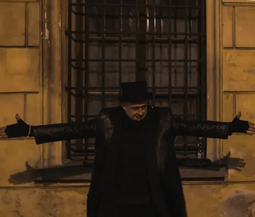 Reiseleiter mit Zylinder vor einem alten Gebäude.