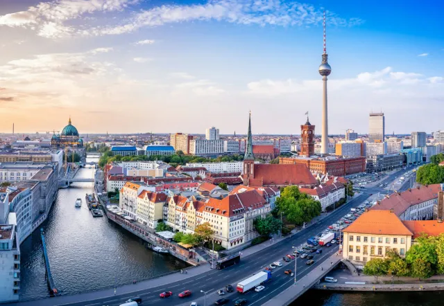 Panoramic view of Berlin's skyline at sunset, featuring iconic landmarks.