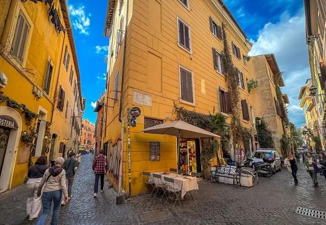 Touristen erkunden die charmanten Kopfsteinpflasterstraßen von Trastevere, Rom.