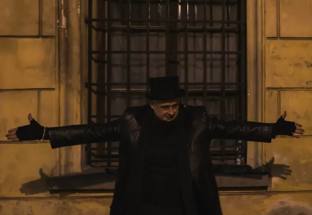 Reiseleiter mit Zylinder vor einem alten Gebäude.