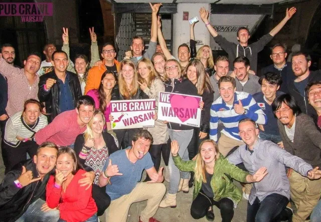 Eine große Gruppe fröhlicher Touristen auf einem Kneipenbummel in Warschau, Polen.