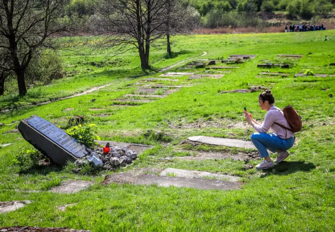 Tourist taking a photo at the Płaszów memorial in Krakow, Poland.