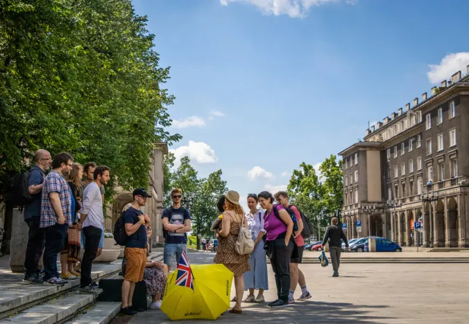 Un grupo de turistas guiados explora una soleada plaza de la ciudad en Cracovia, Polonia.