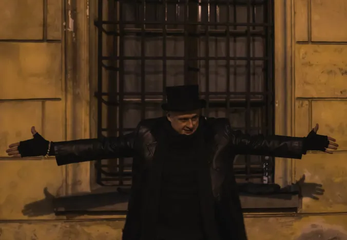 Guía turístico con sombrero de copa frente a un edificio antiguo.