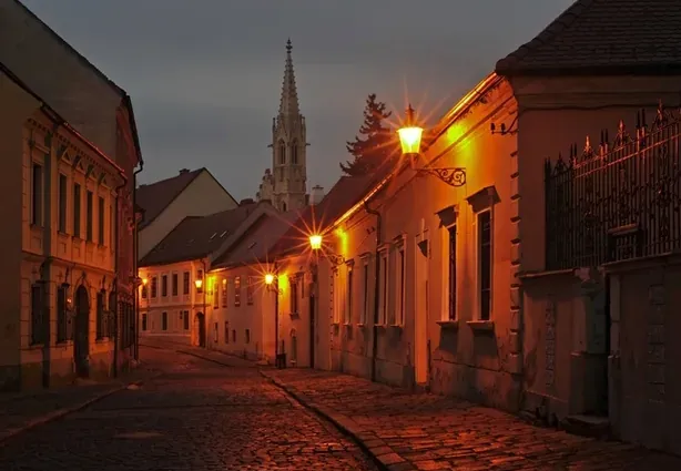 Recorrido misterioso por Bratislava: Una encantadora calle adoquinada de noche.