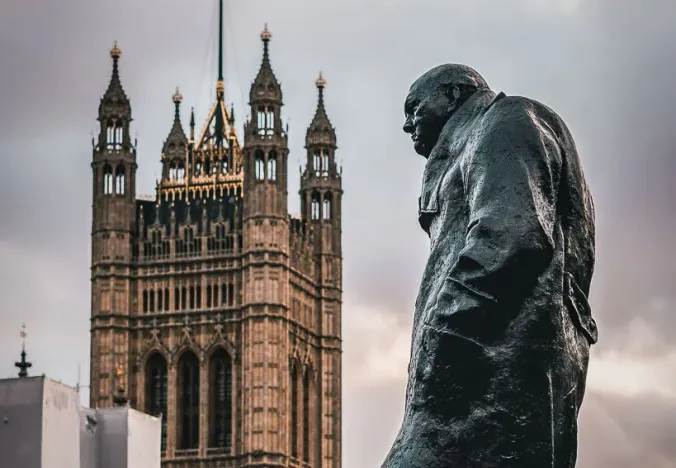 Statue von Winston Churchill mit dem Palace of Westminster im Hintergrund in London.