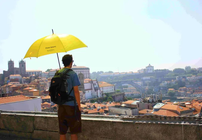Turista disfrutando de un tour gratuito a pie en Oporto, Portugal.