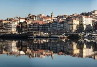 Vista panorámica del distrito de Ribeira en Oporto reflejada en el río Duero.